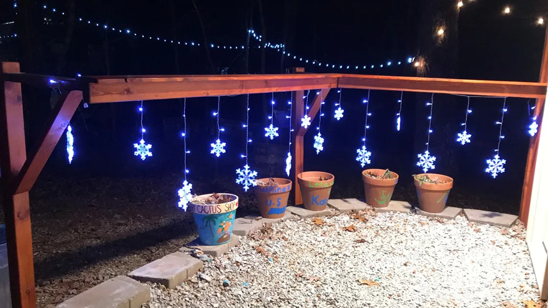 Blue Stringlights Hanging Teracotta Pot Outdoors Angle View Snowflake Christmas Lights